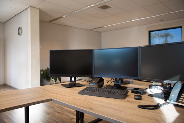 Ingerichte kantoorwerkplekken met dubbele schermen